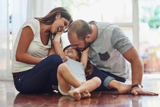Family time is a fun time. a mother and father bonding with their adorable young daughter at home