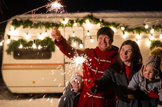 Happy parents with two sons celebrating christmas in motorhome.
