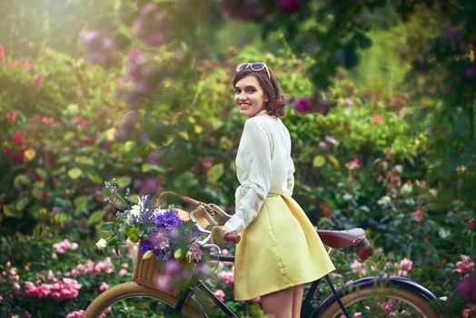 Her beauty outshines even the picturesque landscape. Portrait of an attractive young woman riding a bicycle outdoors.