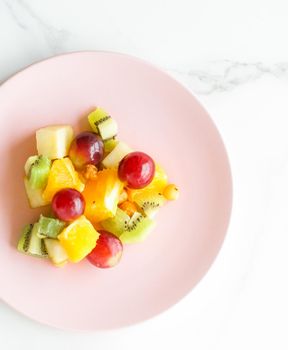 juicy fruit salad for breakfast on marble, flatlay - dieting and healthy lifestyle concept