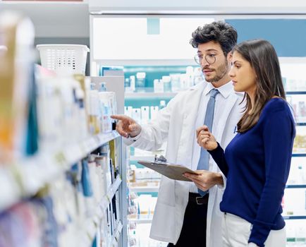 This product should clear your symptoms. a pharmacist assisting a customer in a pharmacy.