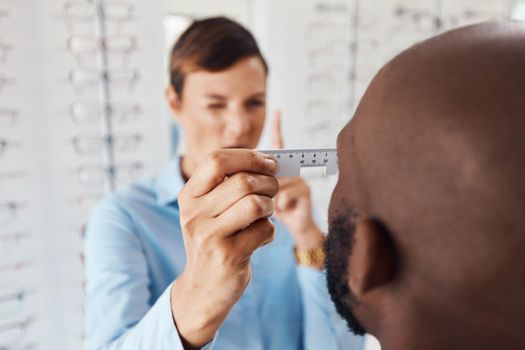 Optometrist, doctor and specialist checking vision retina measurement and sight of a patient with optical PD ruler during eye test in a clinic. Eye doctor giving treatment for prescription glasses