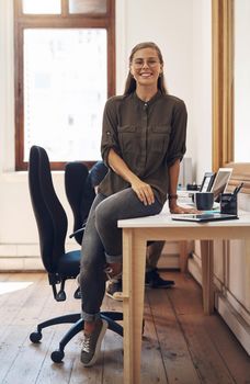 Creative startup entrepreneur and leader, motivation and inspiration for young females. Happy caucasian business woman and owner of consulting agency you can trust, sitting and smiling on work desk.