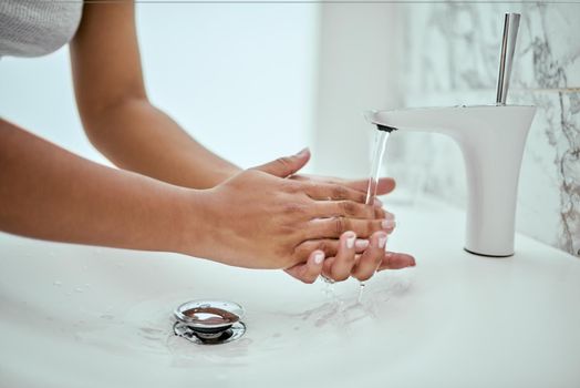 Washing your hands is essential to living a healthy life. an unrecognizable womans hands being washed at a basin in a bathroom at home during the day.