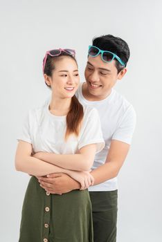 Young couple embracing and posing on white background