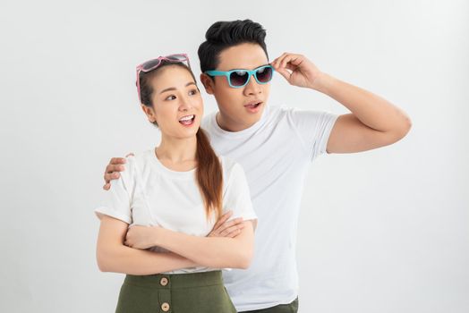 Surprised young couple looking at camera. Front view of excited young man and woman standing together and looking at camera on white background. Emotion concept