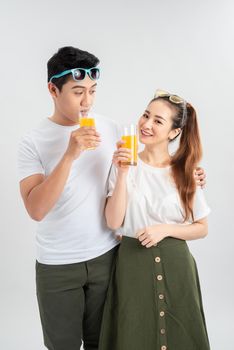 love, family, healthy food and happiness concept - smiling happy couple drinking juice on white background