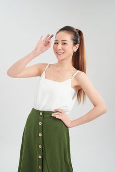 Cheerful young Asian woman with ok sign while standing over white background.