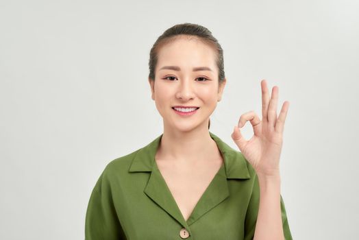 Portrait of young Asian businesswoman with sign gesture