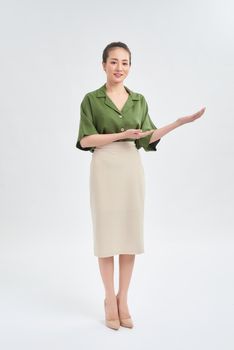 Full length of young Asian businesswoman showing her hand and standing isolated over white background.