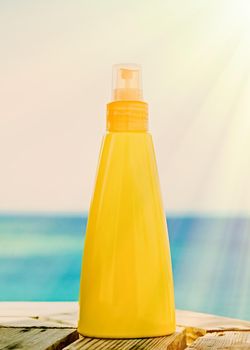 sun tan lotion on the beach - skincare cosmetics and holiday concept