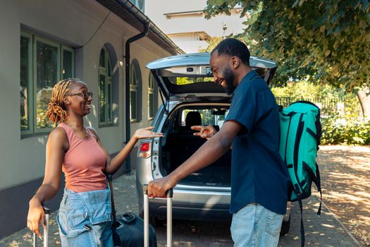 African american partners loading suitcase in trunk