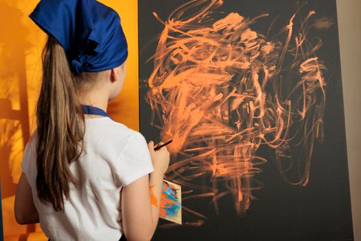 Young painter painting masterpiece with orange