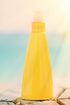 sun tan lotion on the beach - skincare cosmetics and holiday concept