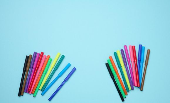 Stack of multicolored felt-tip pens on a blue background