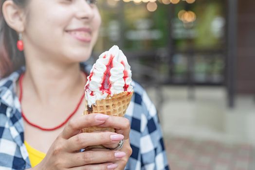 cheerful trendy woman with red hair eating ice cream at street