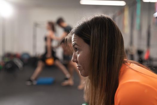 Candid portrait of a female trainee resting at the gym
