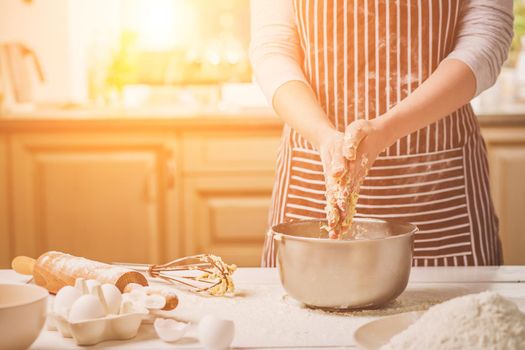 Woman hands kneading dough in iron bowl