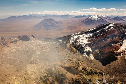 Atacama desert, snowcapped Lascar volcano crater and arid landscape in Chile