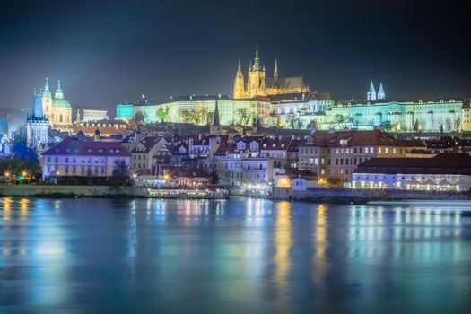 Hradcany quarter and Vltava river at night with blurred boat movement, Prague