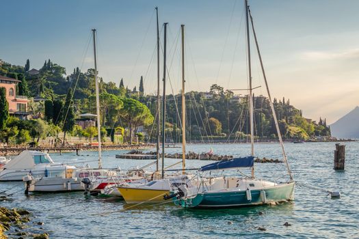 Idyllic lake Garda coastline and mediterranean village with sailboats, Italy