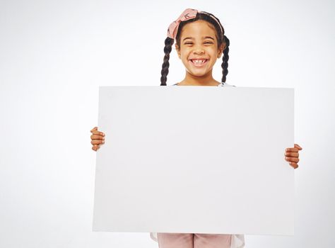 Put a smile on your kids face. Studio shot of an adorable little girl holding a blank placard.