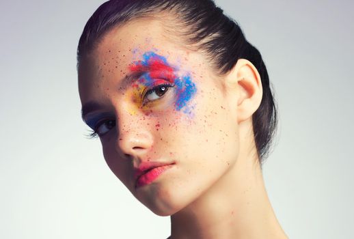 What does you makeup say about you. Studio shot of an attractive young woman with brightly colored makeup against a gray background.