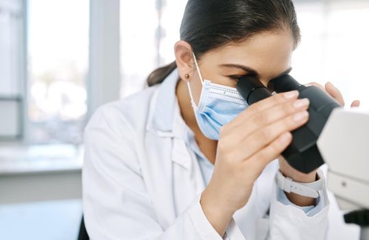 Its vital to have a critical eye in the lab. a young scientist using a microscope in a lab.