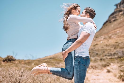 Happy, loving and young couple embracing each other on a getaway in nature with copyspace. Girlfriend and boyfriend on a romantic summer vacation. Cheerful, smiling and caucasian partners hugging.