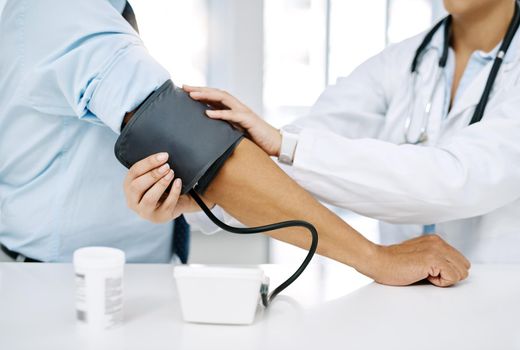 Lets check on your vitals. Closeup shot of a doctor checking a patients blood pressure in a hospital.