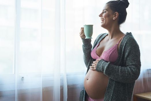 Maternity leave is great. an attractive young pregnant woman standing in her bedroom at home.