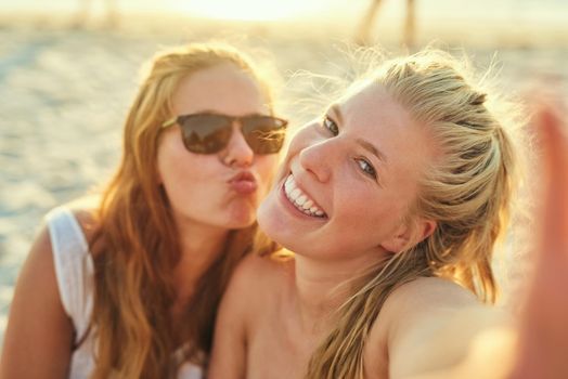 Soaking in the sun and the fun. young female best friends hanging out at the beach.
