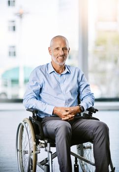 My wheels get me to where I need to be. Portrait of a mature man sitting in a wheelchair.