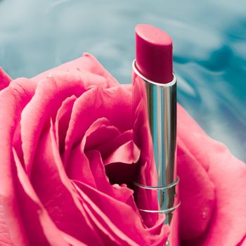 luxe red lipstick and a wonderful rose - make-up and cosmetics styled beauty concept