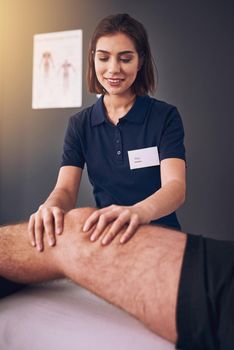 This knee is healing nicely. an attractive young female physiotherapist treating a male patient.