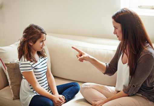 Discipline starts at home. a young girl being reprimanded by her mother at home.