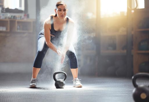 Fitness kettlebell and gym woman with chalk on hands during weightlifting workout, exercise or training. Athletic, active and strong girl exercising with weight equipment to build muscle strength