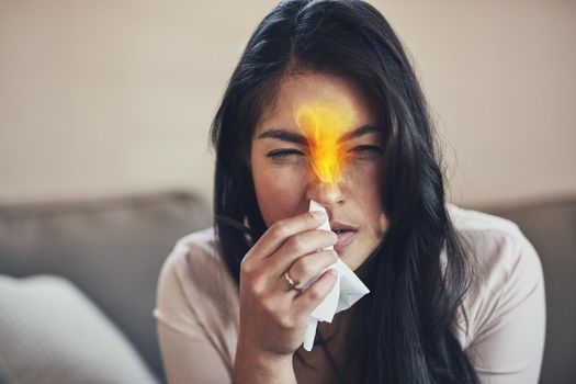 Seasonal allergies can cause nose burning and congestion. a young woman blowing her nose at home.