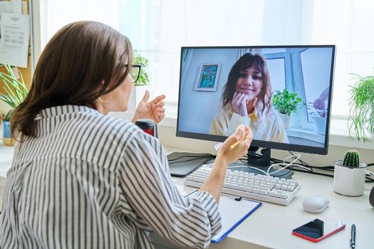 Mature woman talking online with teenage girl using video call
