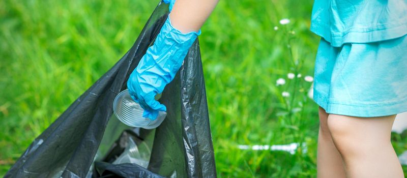 Child puts plastic in garbage bag