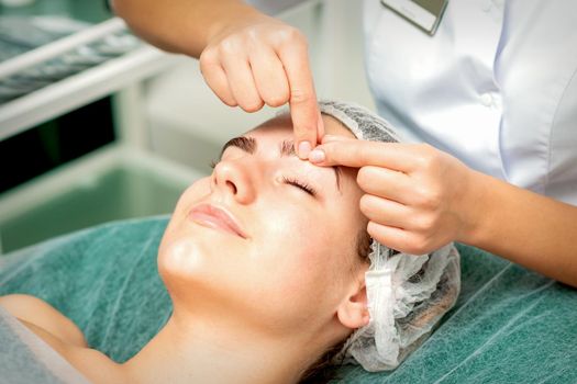 Beautician make massage on eyebrow
