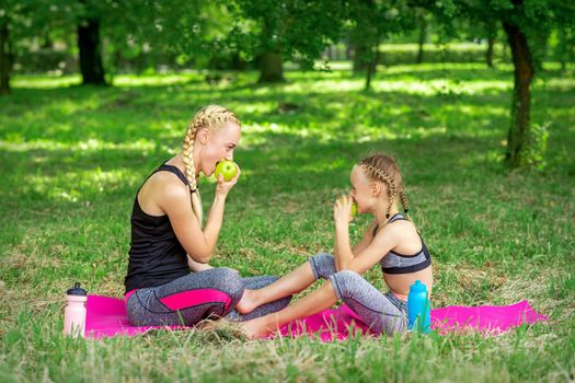Mother with daughter eats apples