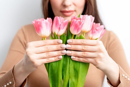 Young woman holds pink tulips