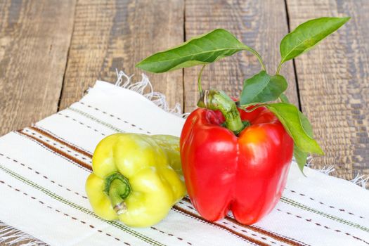 Ripe red and yellow bell peppers on kitchen napkin