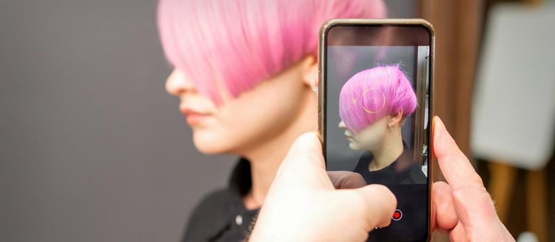 Hairdresser takes pictures of hairstyle