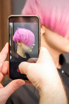 Hairdresser takes pictures of hairstyle