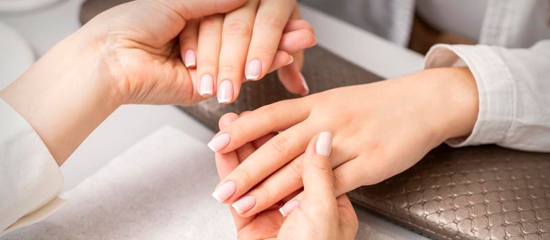 Manicurist showing manicure on fingers