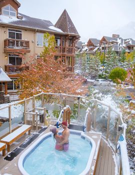 couple in hot tub during snow in the Canadian rockies in Canada, men and woman in hot tub