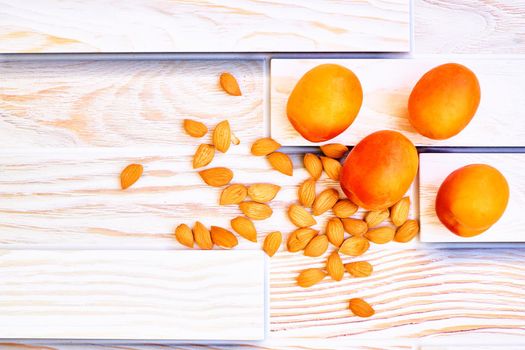 Fresh ripe apricot fruits with kernels isolated on wood background