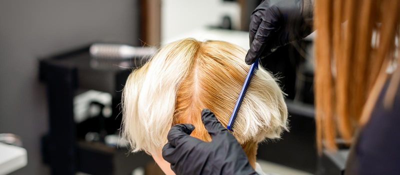 Hairdresser combing female short hair